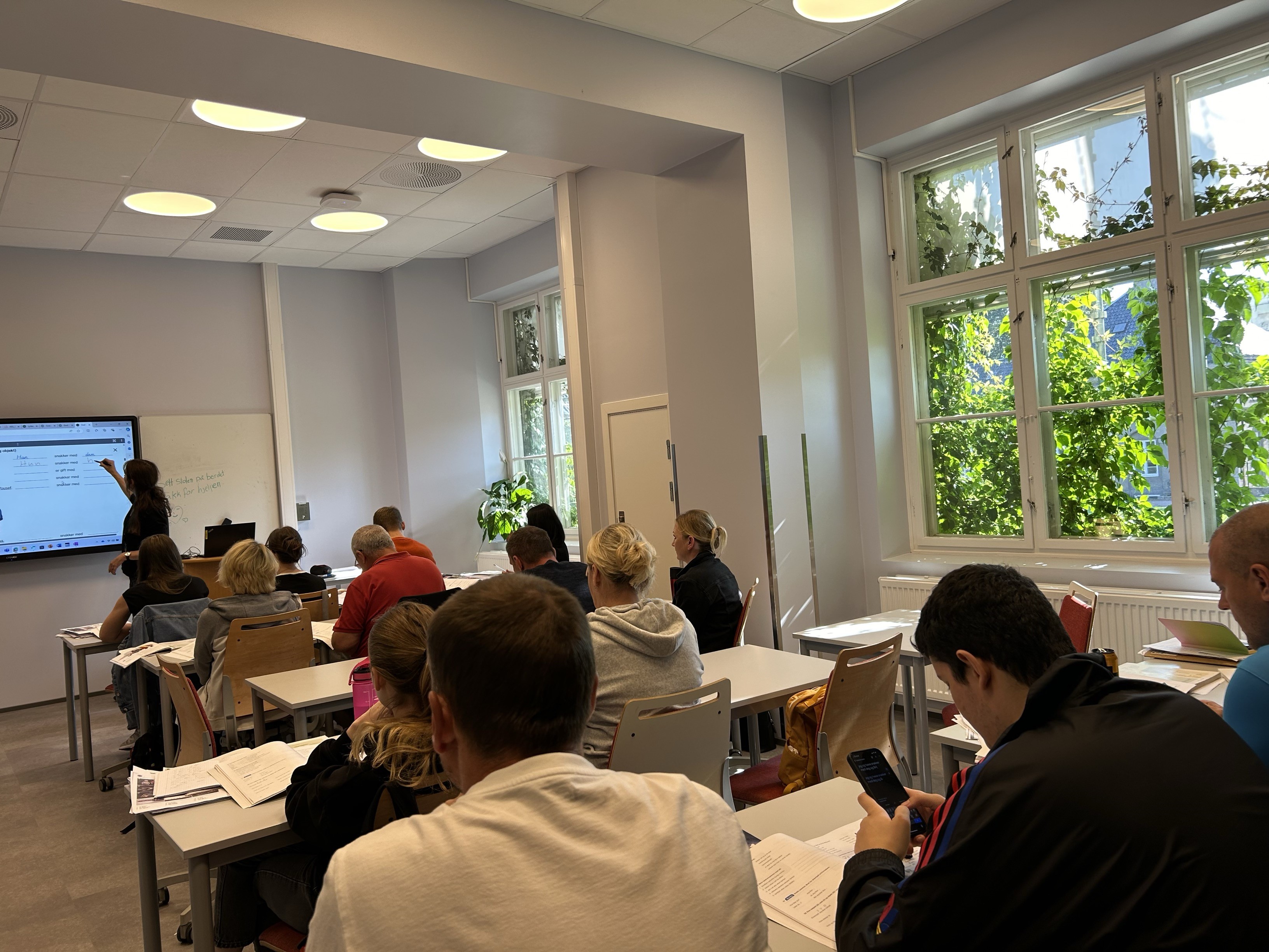 en gruppe mennesker som sitter i et rom med datamaskiner