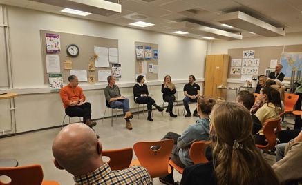 en gruppe mennesker som sitter i et rom