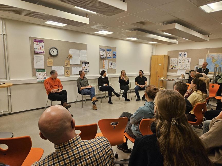 en gruppe mennesker som sitter i et rom