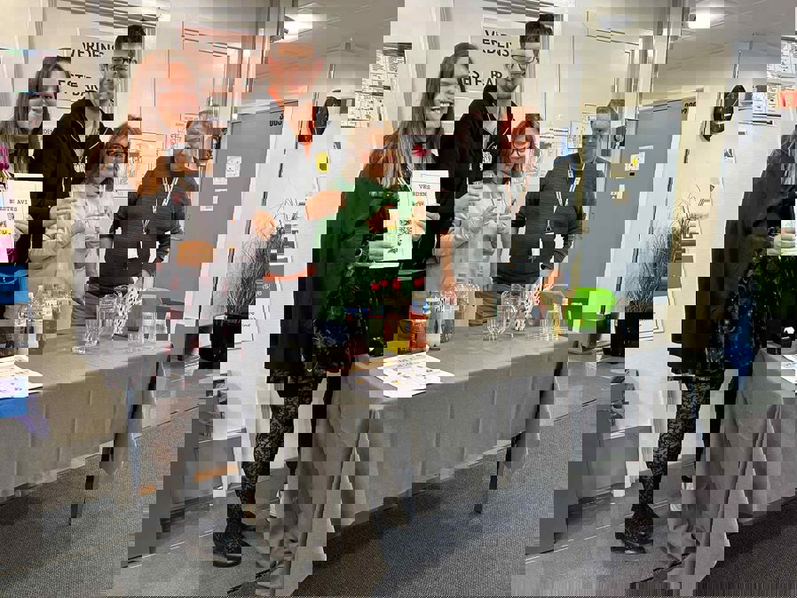 en gruppe mennesker som står rundt et bord med et skilt