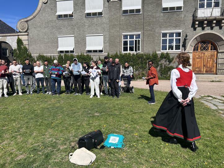 en gruppe mennesker som ser en person spille et musikkinstrument en gruppe mennesker som ser en person spille et musikkinstrument