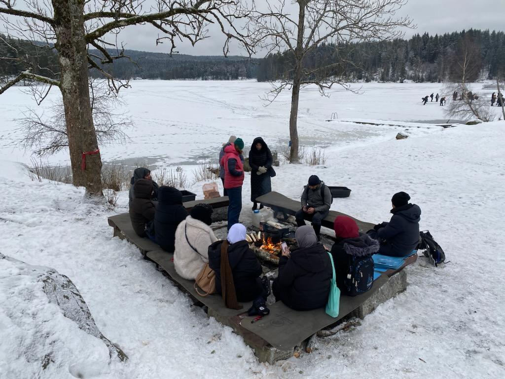 en gruppe mennesker som sitter rundt et bord med mat på