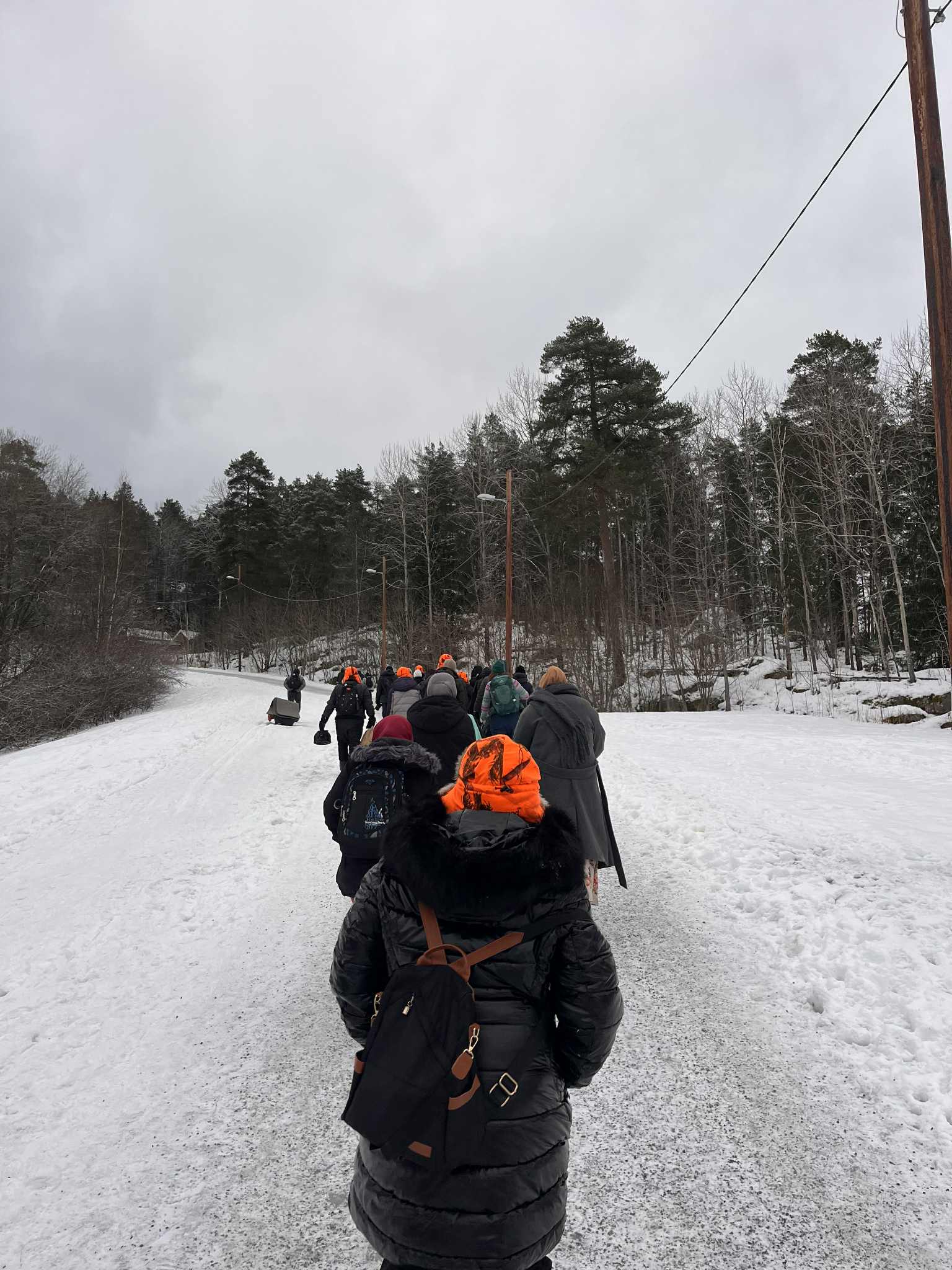 En gruppe mennesker som går tur i snøen