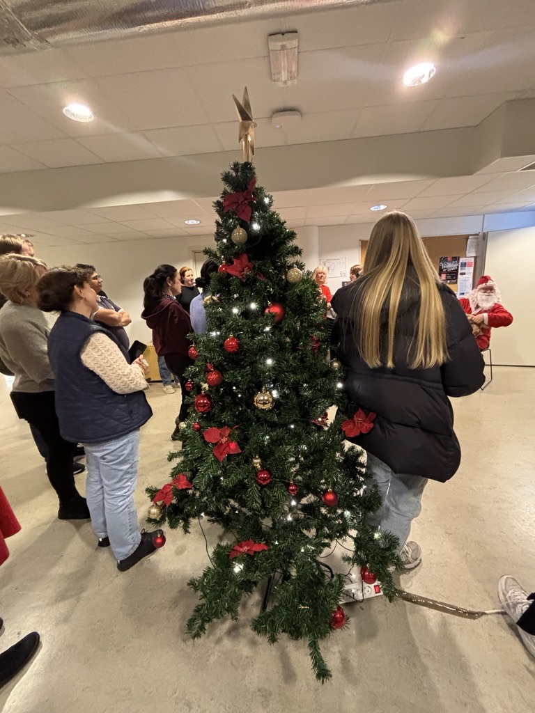 En gruppe mennesker rundt et juletre