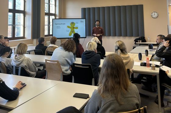en person som holder en presentasjon for en gruppe mennesker